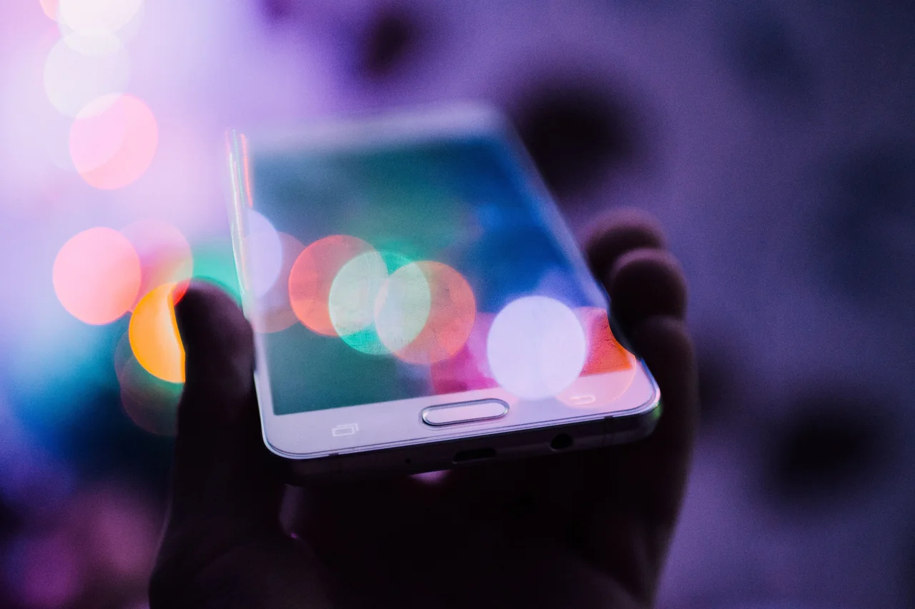 Bokeh & a hand holding a white phone